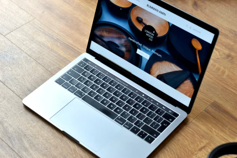 A MacBook Pro turned on, on a brown wooden surface
