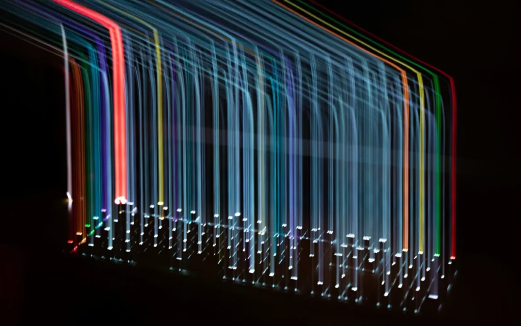 Long-exposure streaks of coloured light in the dark above a keyboard
