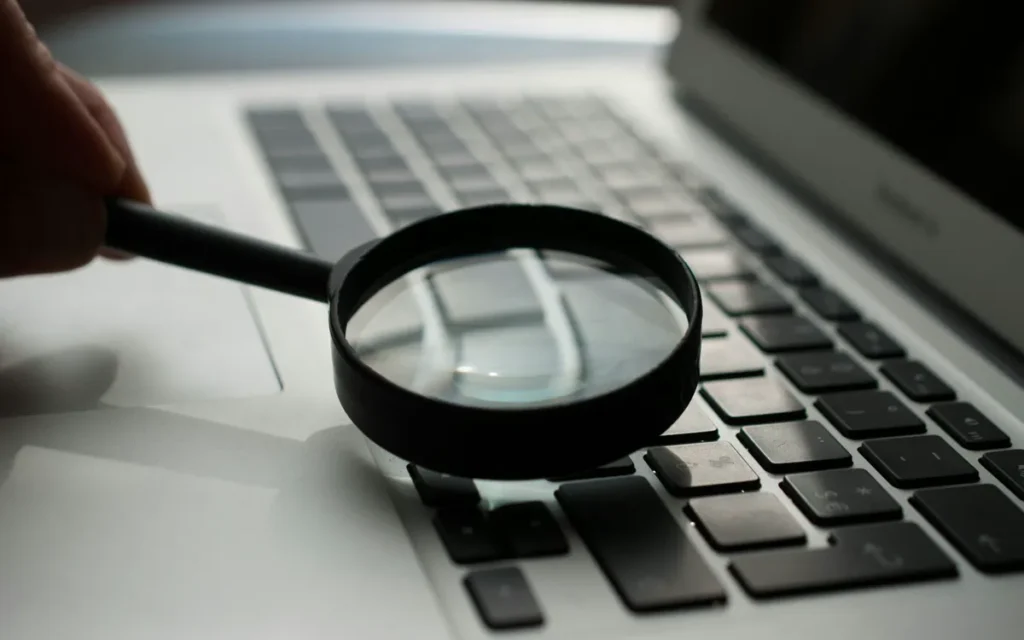 Magnifying glass resting on a grey laptop