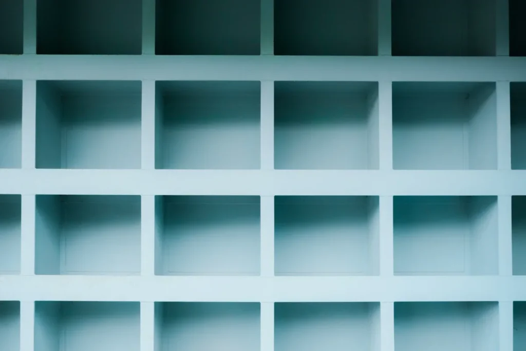Rows of empty pale blue square shelves in a wall unit