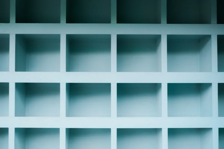 Rows of empty pale blue square shelves in a wall unit